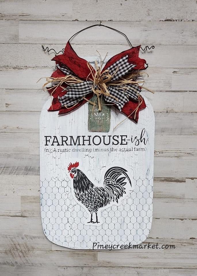 a sign hanging from the side of a wooden wall with a rooster on it's back