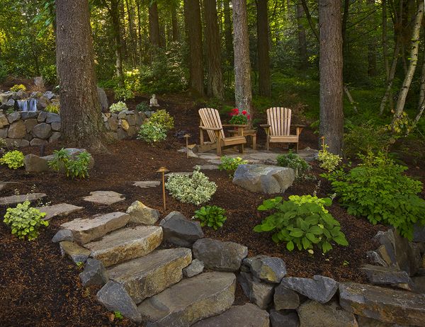 an image of a garden with rocks and plants on the bottom right side of it