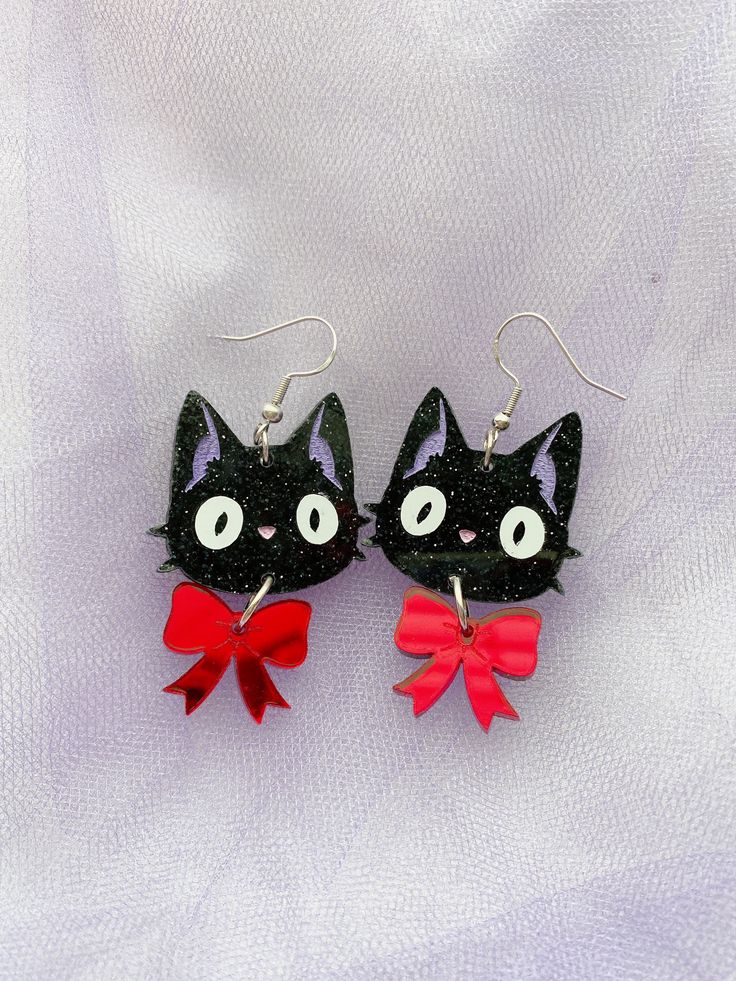 Earrings inspired by Kiki's faithful sidekick and best friend. Jiji is made with black glitter acrylic, with hand-painted features, and vinyl cut eyes. His bow is made with red mirror acrylic! Jiji is about 5 centimeters with his bow! Light weight and fun accessory for any Studio Ghibli fan! Kikis Delivery Service Earrings, Ghibli Earrings, Studio Ghibli Earrings, Bow Light, Weird Jewelry, Acrylic Earring, Fancy Cats, Red Mirror, Funky Earrings