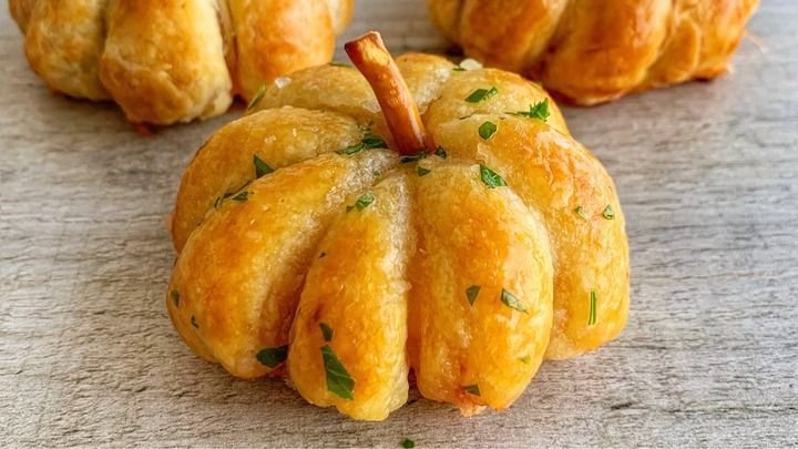 small pumpkin shaped pastries sitting on top of a table