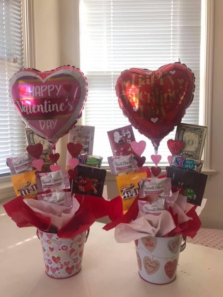 two valentine's day gifts in small buckets on a table next to a window