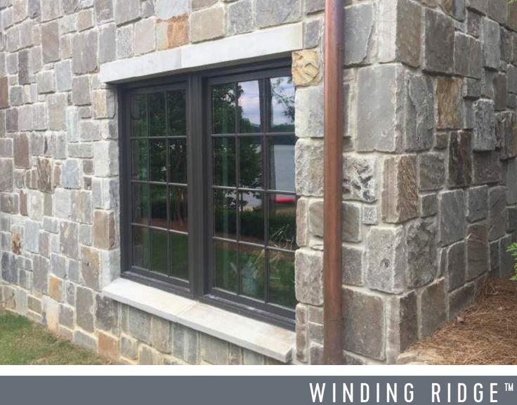 a stone building with two windows on each side and the words winding ridge above it