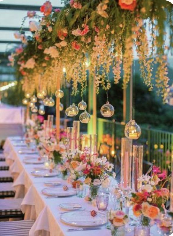 a long table with flowers and candles is set up for an outdoor dinner or party