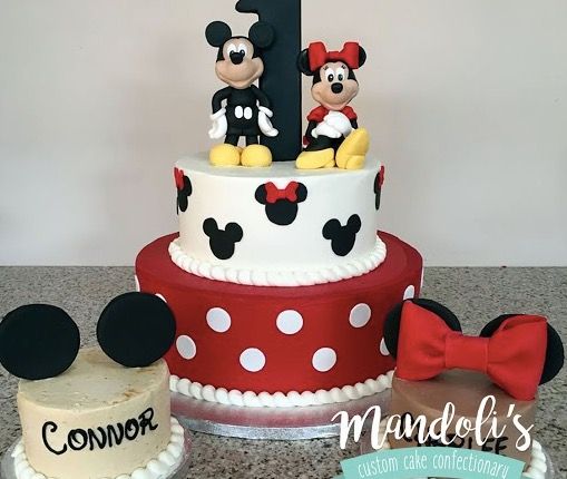 a mickey and minnie mouse birthday cake with the number one on top