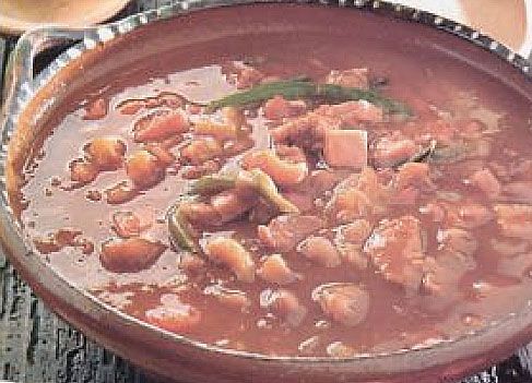 a bowl filled with soup sitting on top of a wooden table