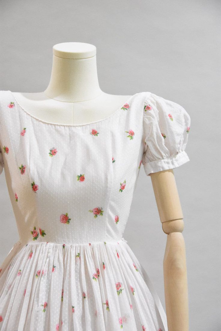 "Vintage 1950s daydress. White swiss cotton with rose print bodice, puff sleeves, seamed bust and nipped waist. Full skirt with a layer of crinoline underneath. Rose tree at hem. Back metal zip closure. Loops for belt, no belt. Fully lined, ever so slightly sheer. State of garment | very good, light overall wear. Measurements ✂--- Best fit | XXS Bust | up to 33 \" Shoulders | 14\" Shoulder to waist | 14\" Sleeves | 7 \" Waist | 22\" Hips | free Total length (shoulder to hem) | 41\" Tag | Muriel Fitted Cotton Dress With Rose Print, 1950s Cotton Dress, 1950s Cotton Spring Dresses, 1950s Cream Spring Dresses, Vintage Dress, 80’s Outfits, Floral 1950s Dress, 1950s A-line Dresses With Floral Print, Vintage Pink Rose Print Dress