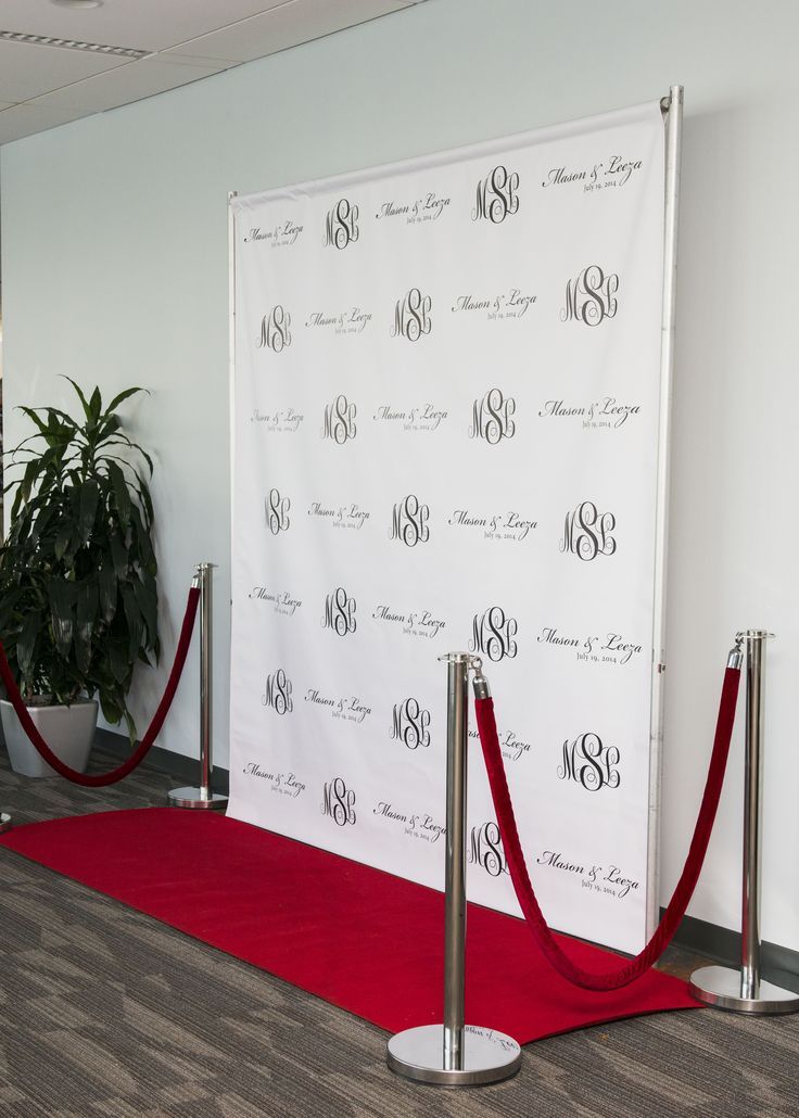 a red carpeted area with two poles and a white backdrop