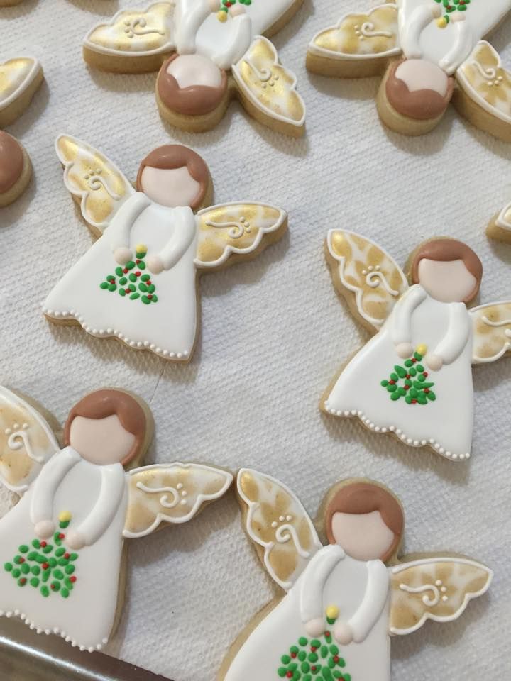 decorated cookies in the shape of angels on a baking sheet