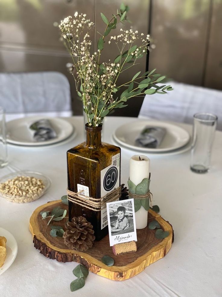 the table is set with plates, candles and flowers in vases on wood slices