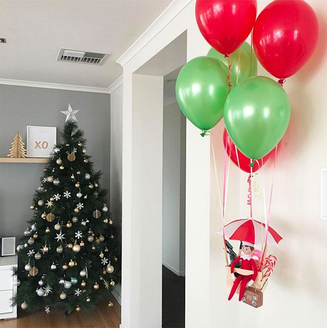 a christmas tree with red and green balloons hanging from it