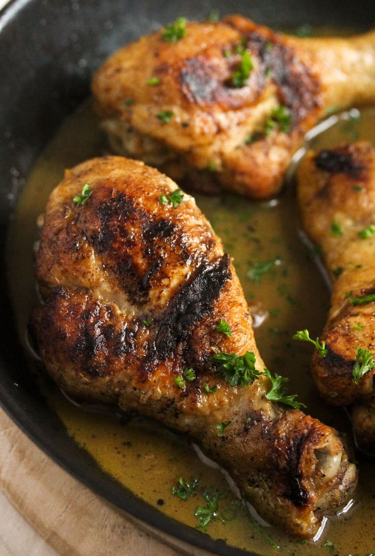 three pieces of meat in a pan with some parsley on the top and side