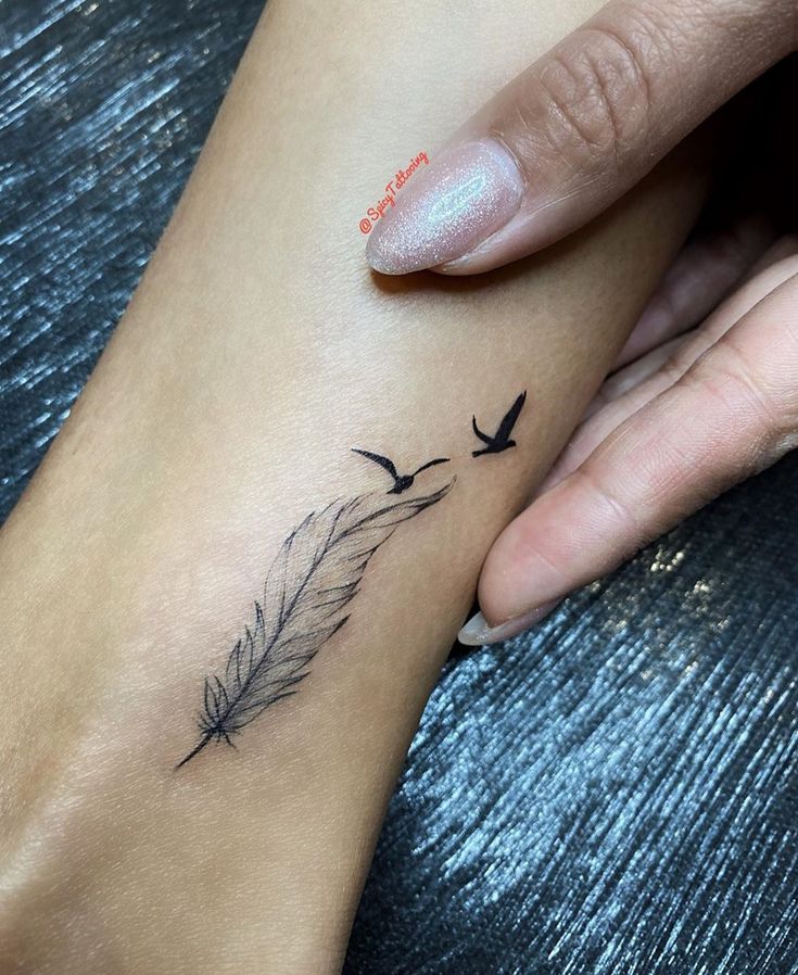 a woman's foot with a bird tattoo on it