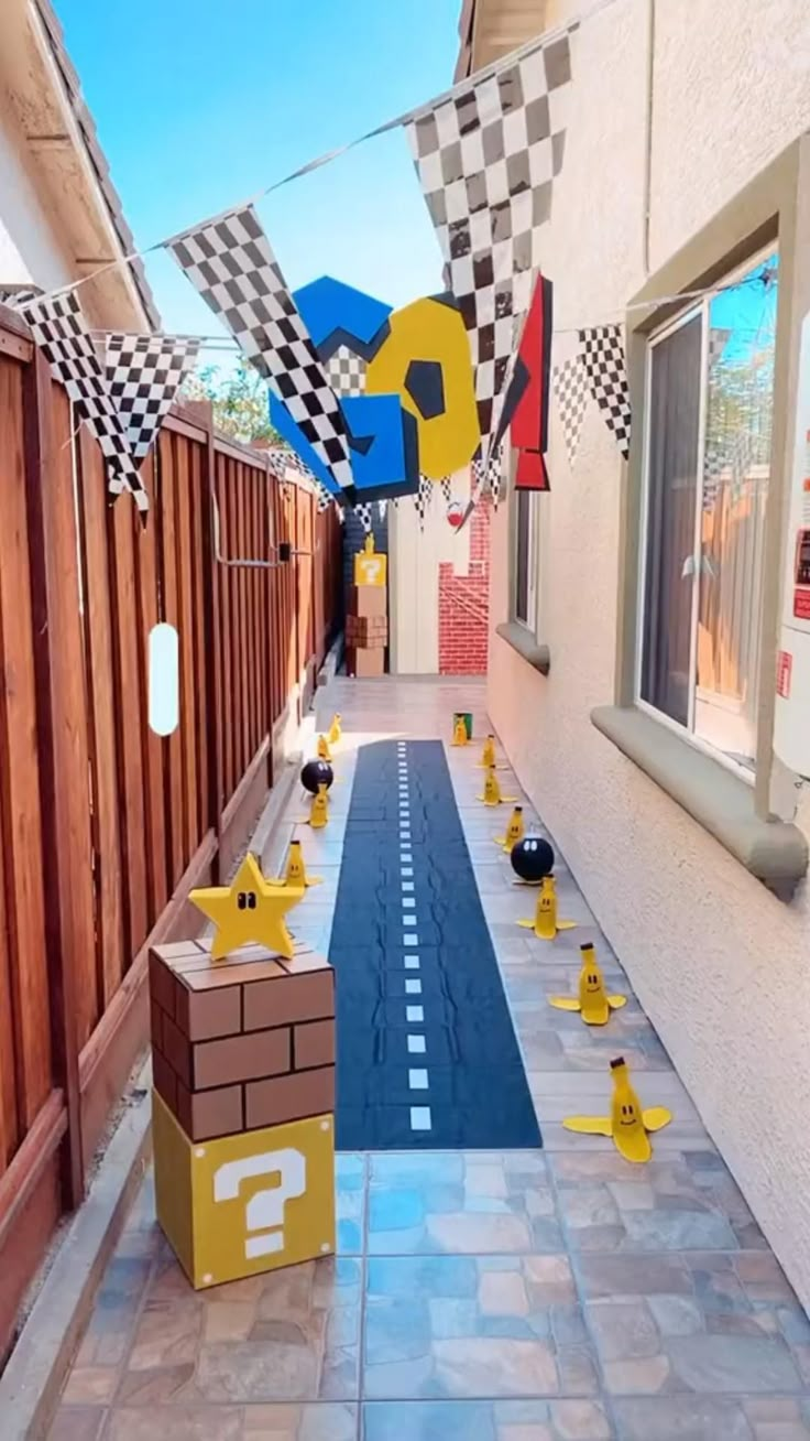 an alley decorated with yellow rubber ducks and checkered buntings for a race themed birthday party