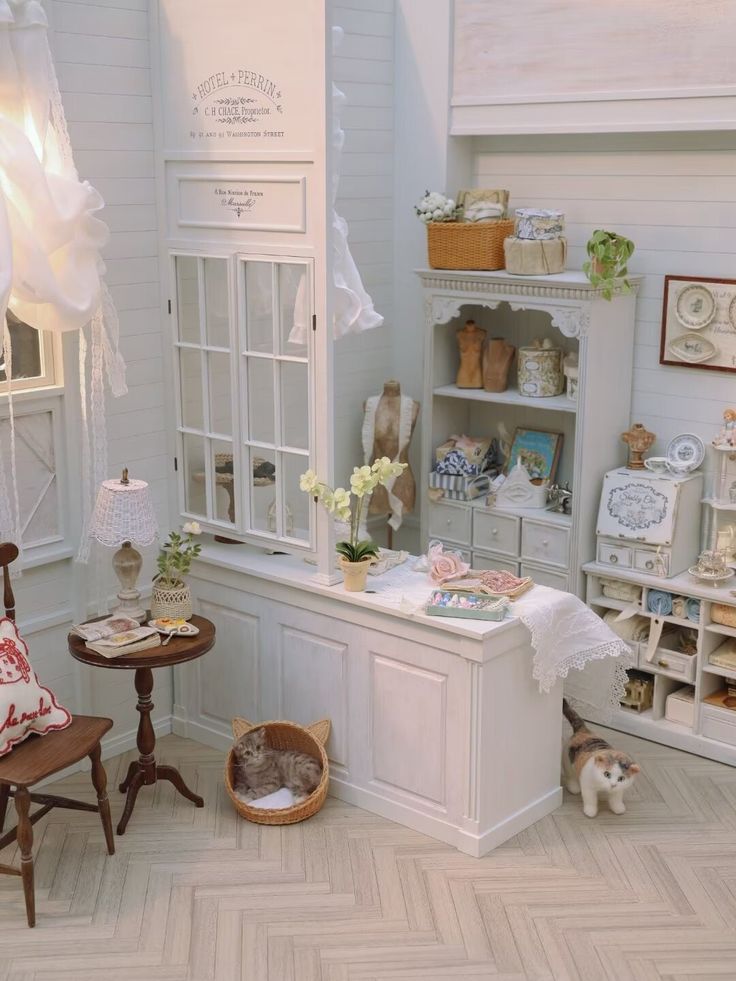 there is a cat sitting in the corner of this dollhouse room with furniture and accessories