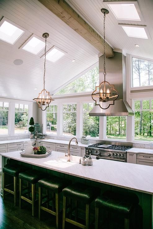 a large kitchen with an island in the middle and lots of windows on both sides