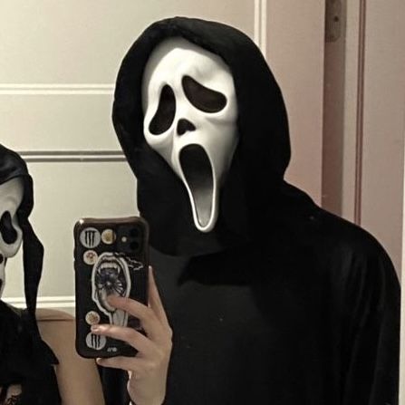 two people in halloween costumes are taking a selfie with their cell phone while wearing masks