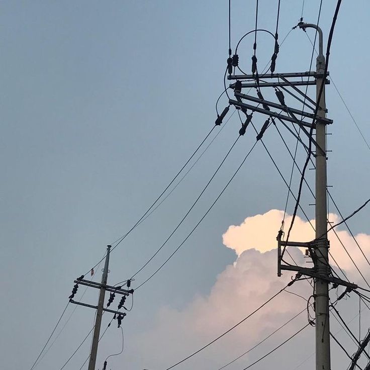 power lines and wires against a blue sky with clouds in the background