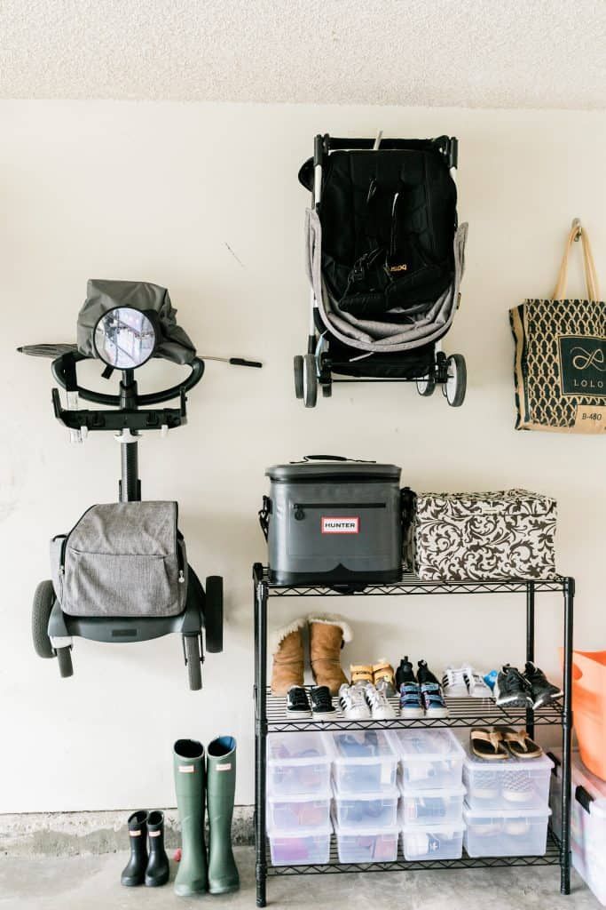 there are many shoes and bags on the shelves in this room, including one with a stroller