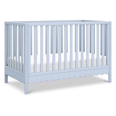 a baby crib with white sheets on the bottom and sides, in front of a white background