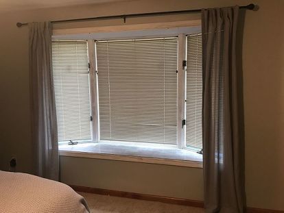 a bed sitting under a window in a bedroom