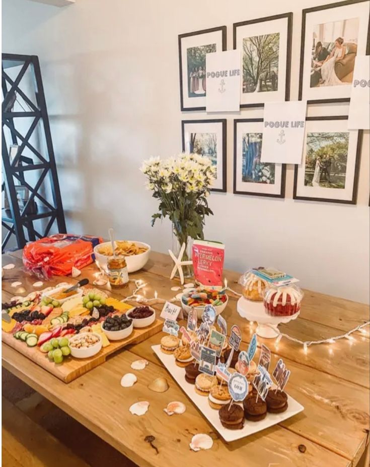 a wooden table topped with lots of desserts and pastries on top of it