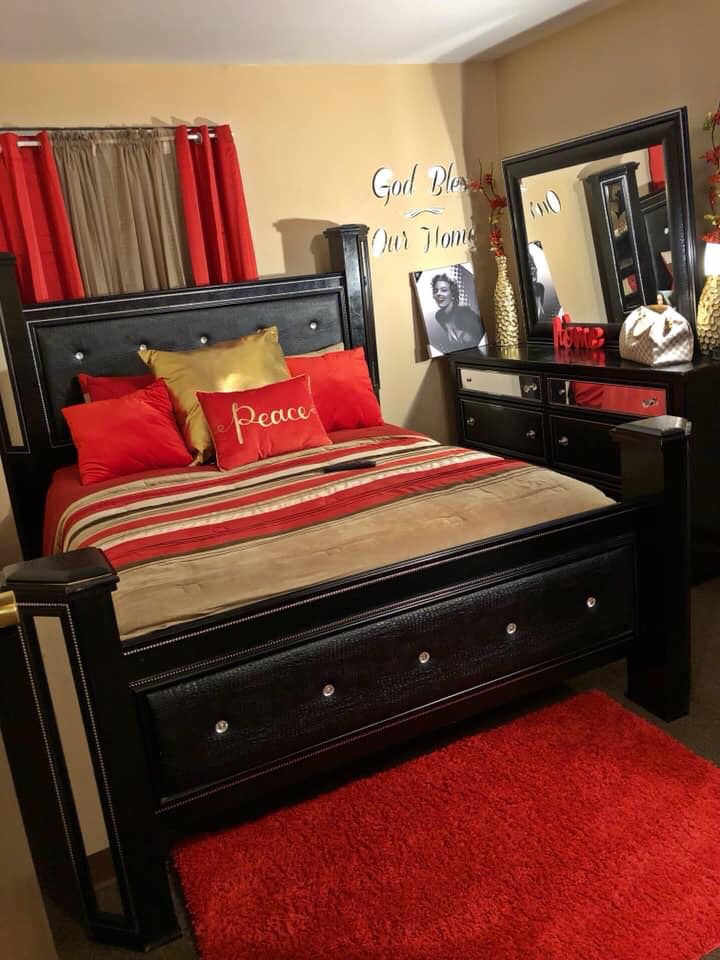 a bed room with a neatly made bed and red rugs