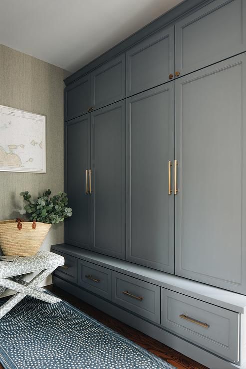 a room with gray cabinets and a blue rug on the floor next to an area rug