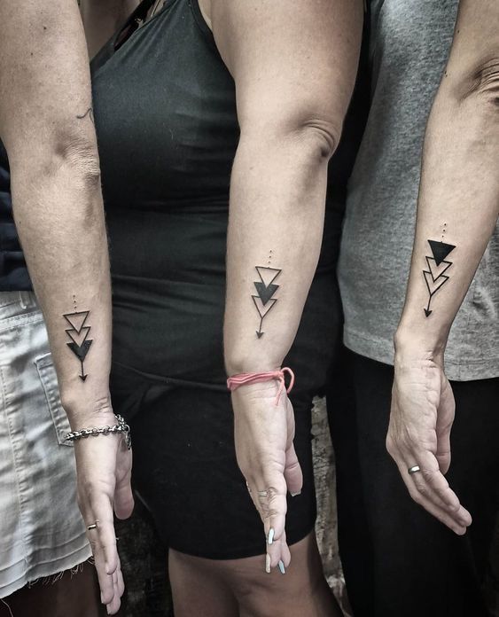 three people with matching tattoos on their arms