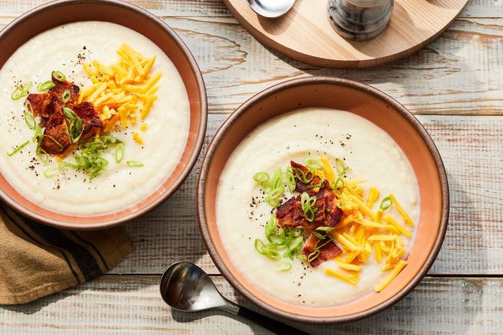 two bowls of soup with cheese and bacon