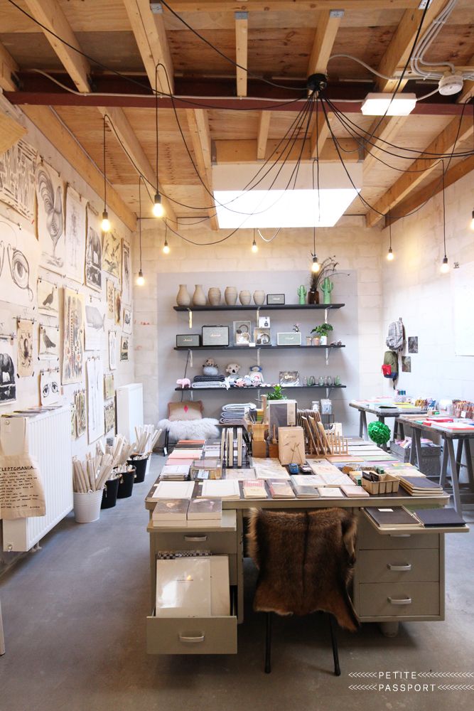 a room filled with lots of desks and shelves covered in pictures on the wall