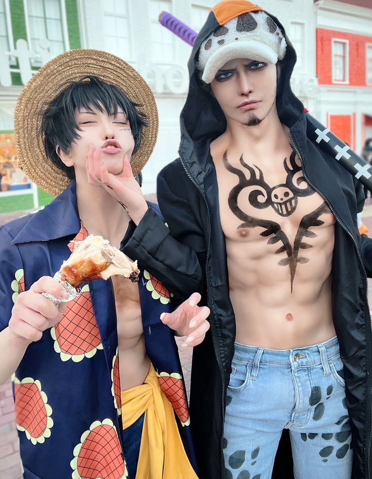 two young men are dressed in costumes and eating donuts while posing for the camera