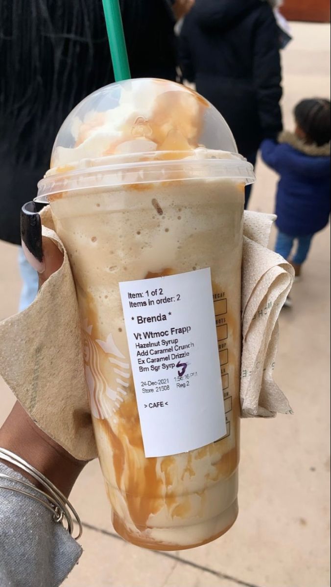 a person holding up a starbucks drink in their hand