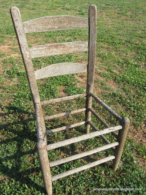 an old wooden chair sitting in the grass