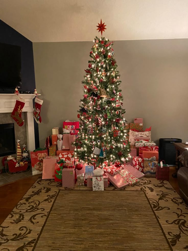 a christmas tree with presents under it in a living room