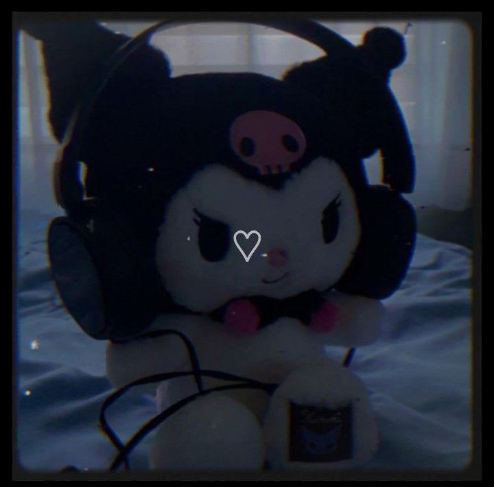 a stuffed animal with headphones sitting on a bed