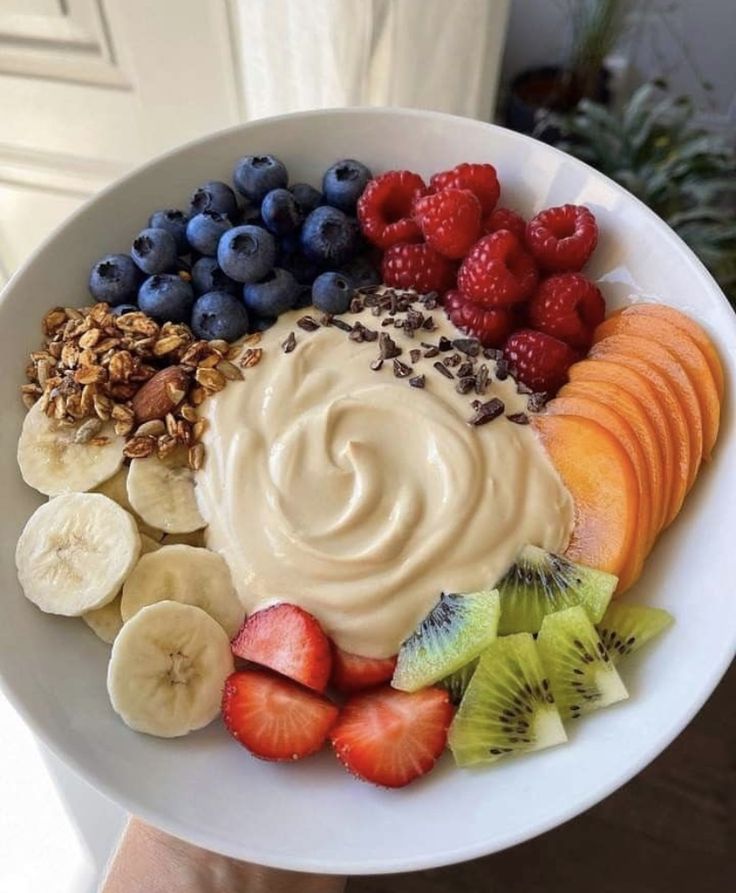 a white bowl filled with fruit and yogurt