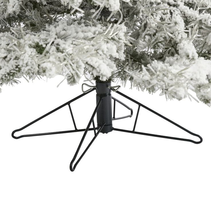 a black and white photo of snow on a pine tree with an upside down stand