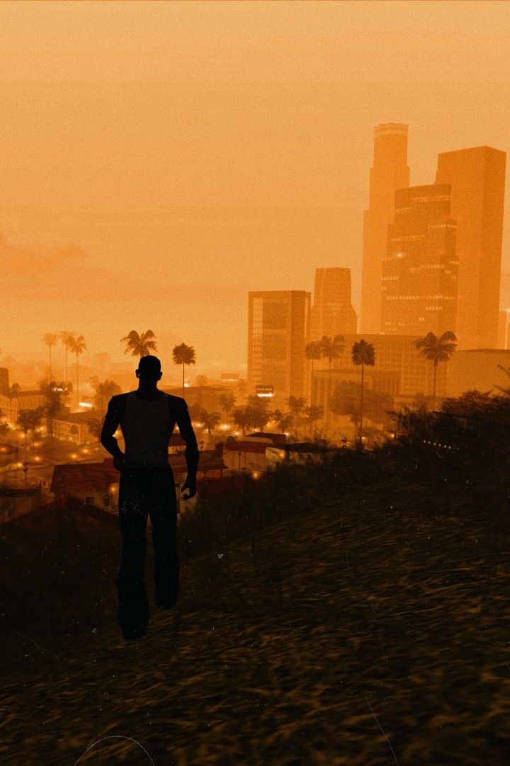 a man standing on top of a lush green field next to a tall city skyline