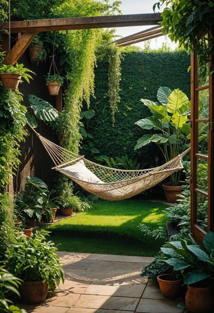 a hammock hanging in the middle of a garden with potted plants and greenery