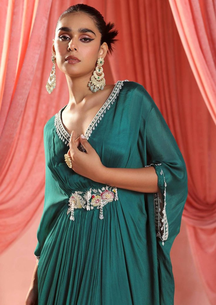 Full length draped kaftan, embellished on the neckline, sleeves and waist. Silk Designer Dress With Draped Sleeves, Designer Silk Dress With Draped Sleeves, Silk Dress With Draped Sleeves For Designer Wear, Anarkali Gown With Cape Sleeves For Evening, Bollywood Style Dresses With Draped Sleeves, Festive Gown With Traditional Draped Sleeves, Anarkali Dresses With Embroidered Neckline, Embellished Anarkali Dress With Cape Sleeves, Anarkali Dresses With Embellished Cape Sleeves