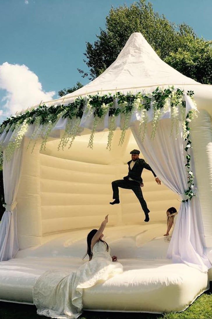 an inflatable wedding tent with two people jumping on the bed and another person laying down