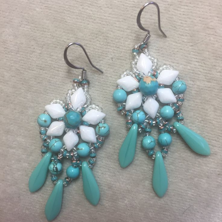 two pairs of turquoise and white beaded earrings on top of a carpeted floor