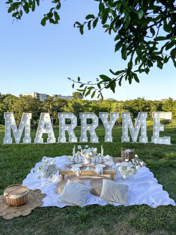 a table set up for a wedding with the word marry me spelled out in large letters