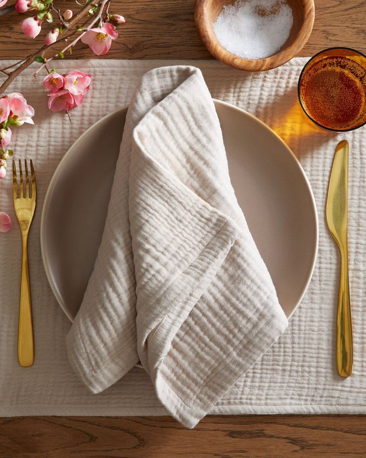 a white plate topped with a fork and knife next to a napkin on top of a wooden table