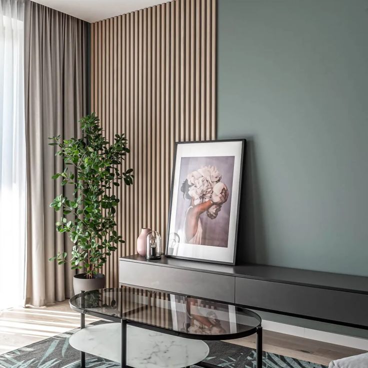 a living room with a glass coffee table and plant in the corner next to it