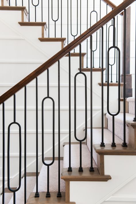 a set of stairs with black railings and white carpet