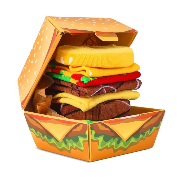 a cardboard box filled with hamburgers and other food items on top of each other