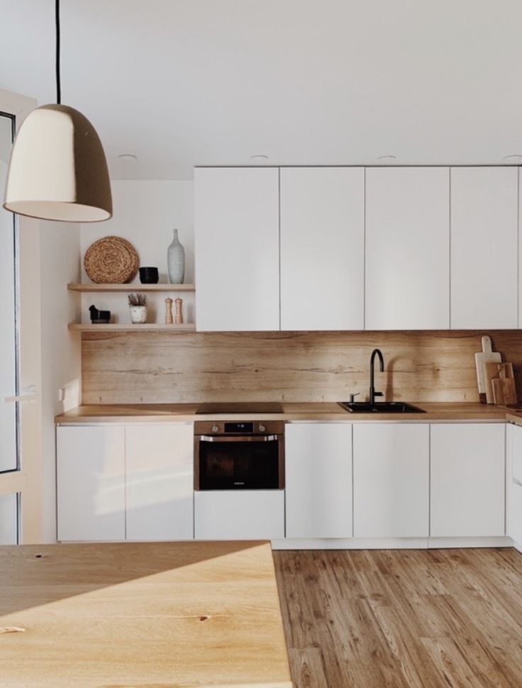 a kitchen with wooden floors and white cabinets