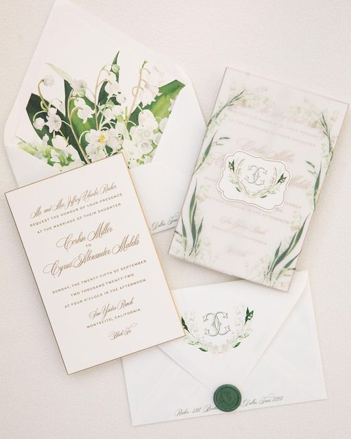 the wedding stationery is laid out on top of each other, including two envelopes