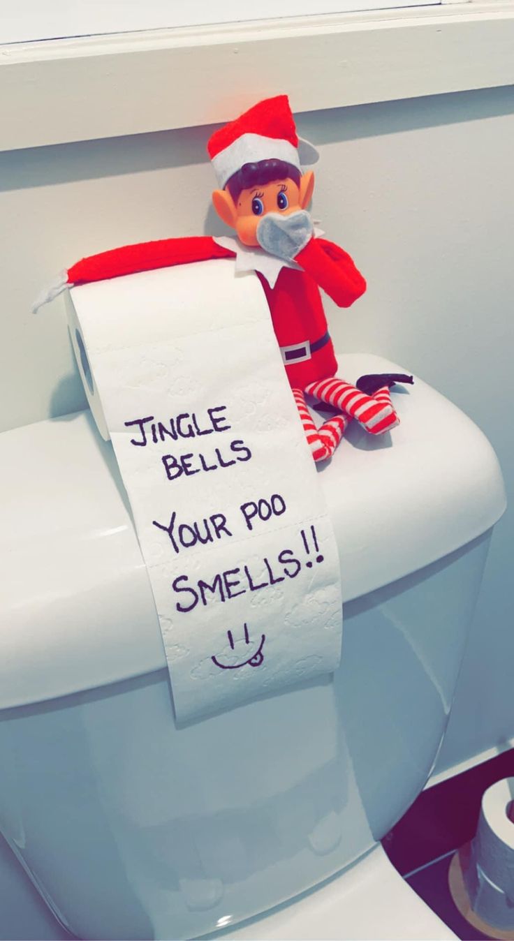 an elf is sitting on top of a toilet with a sign that says, jingle bells your po smells